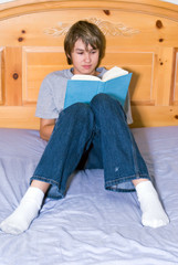 Fototapeta na wymiar Teenager reading in bed
