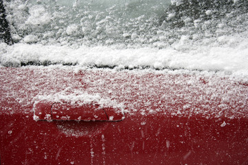 parked car covered with snow during snowing in winter time