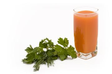 Glass of carrot juice and fresh greens on a white background