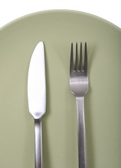 Fork and knife on green plate
