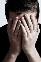 Mental breakdown concept: depressed man covering his face