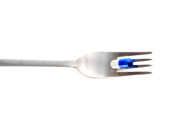 medical pills on fork isolated on white background