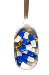 medical pills on fork isolated on white background