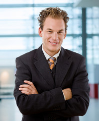 Portrait of happy young businessman smiling at office.