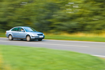 Fototapeta na wymiar Car travelling down country lane, panned motion blur