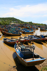 Fototapeta na wymiar a lot of Fisher boats on brown water river