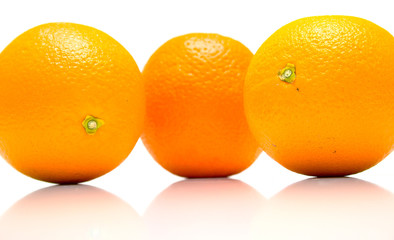 The ripe whole oranges with real reflexion on white