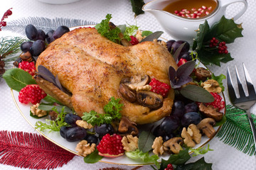 Garnished roasted duck on Christmas decorated table.
