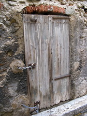 Vieille porte en bois sur mur de pierre.