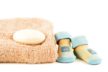 baby sock and soap beside  a towel