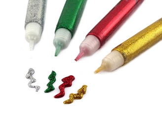 Four tubes of colored glitter glue used in craft and decorating.