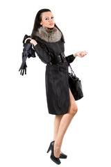 Fototapeta premium The young woman in a black coat. Isolated on white