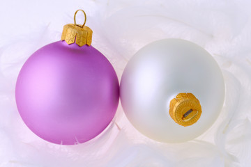 Lilac and white christmas balls on white feathers