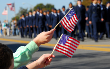 Flag waving at veteran's day parade - obrazy, fototapety, plakaty