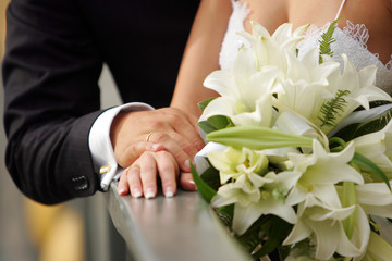 Close up of loving newlywed couple holding hands.