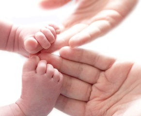 detail of newborn's feet in mother's hands