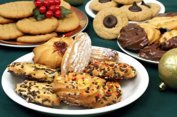 Four plates of assorted holiday cookies.