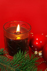 Christmas card. Candle and decoration isolated on red