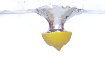 piece lemon in water on white background