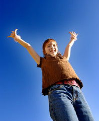 Young joyful girl with arms raised up towards perfect blue sky