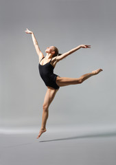 Fototapeta na wymiar young and beautiful ballet dancer posing on gery