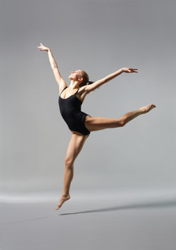 young and beautiful ballet dancer posing on gery
