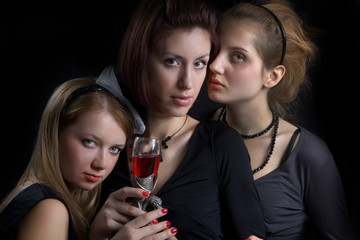 Three pretty girls with the wineglass of red wine.