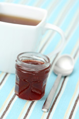 cup of delicious tea with sweet confiture