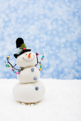 Snowman sitting on snow with snowflake background