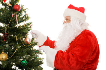 Fototapeta na wymiar Santa Claus decorating a Christmas tree. Isolated on white