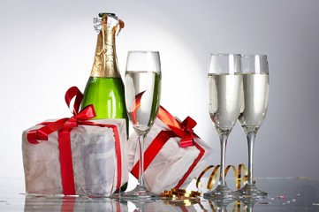 Glasses of champagne, gifts with red tapes and bows