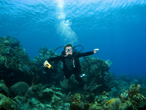 Smiling Scuba Diver descending on a Reef in Cayman Brac
