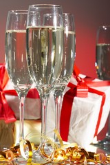 Glasses of champagne, gifts with red tapes and bows