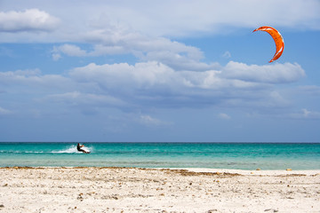 A kitesurfer gliding around the beach Cinta, Sardinia