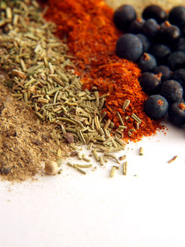 closeup of various colorful spices over white