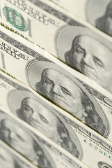 Low-angle view of one hundred dollar bills spread in the row