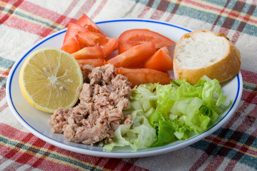 Tuna chunks served with lettuce tomato and lemon
