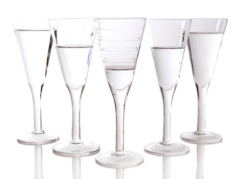 beautiful glasses filled with water on white background