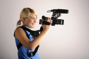 junge blonde Frau mit einer Videokamera