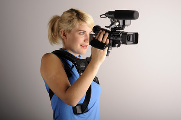 junge blonde Frau mit einer Videokamera