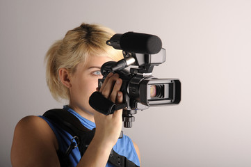 junge blonde Frau mit einer Videokamera