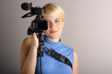 junge blonde Frau mit einer Videokamera