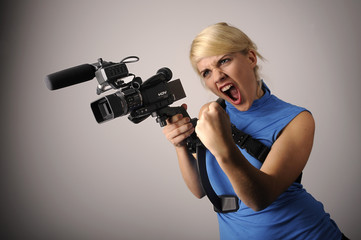 junge blonde Frau mit einer Videokamera - obrazy, fototapety, plakaty
