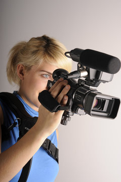 junge blonde Frau mit einer Videokamera