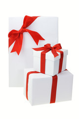 Three white gift boxes with red bow ribbons on white