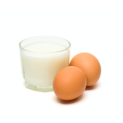 Glass with milk and eggs isolated on white