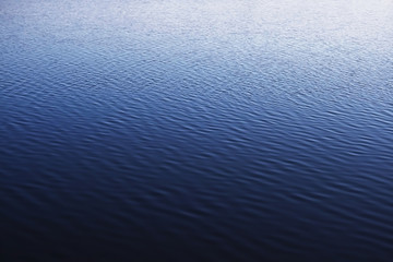 blue water surface of quiet lake with wavelets
