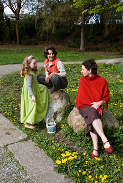 2 women and young girl at park