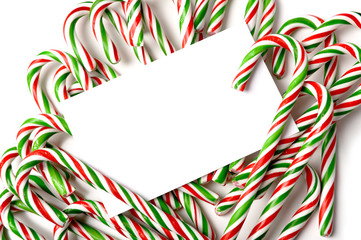 A white notecard surrounded by brightly color Candy Canes