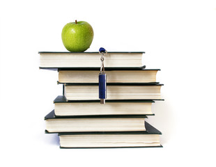 Books stack, flash memory and apple isolated on white
